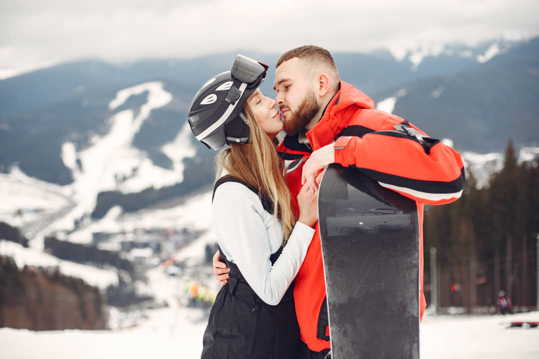 Imagen de una pareja en Sierra Nevada haciendo Snowboard.